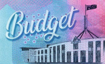 Federal Parliament building on ten dollar note background with the word budget written in cursive.